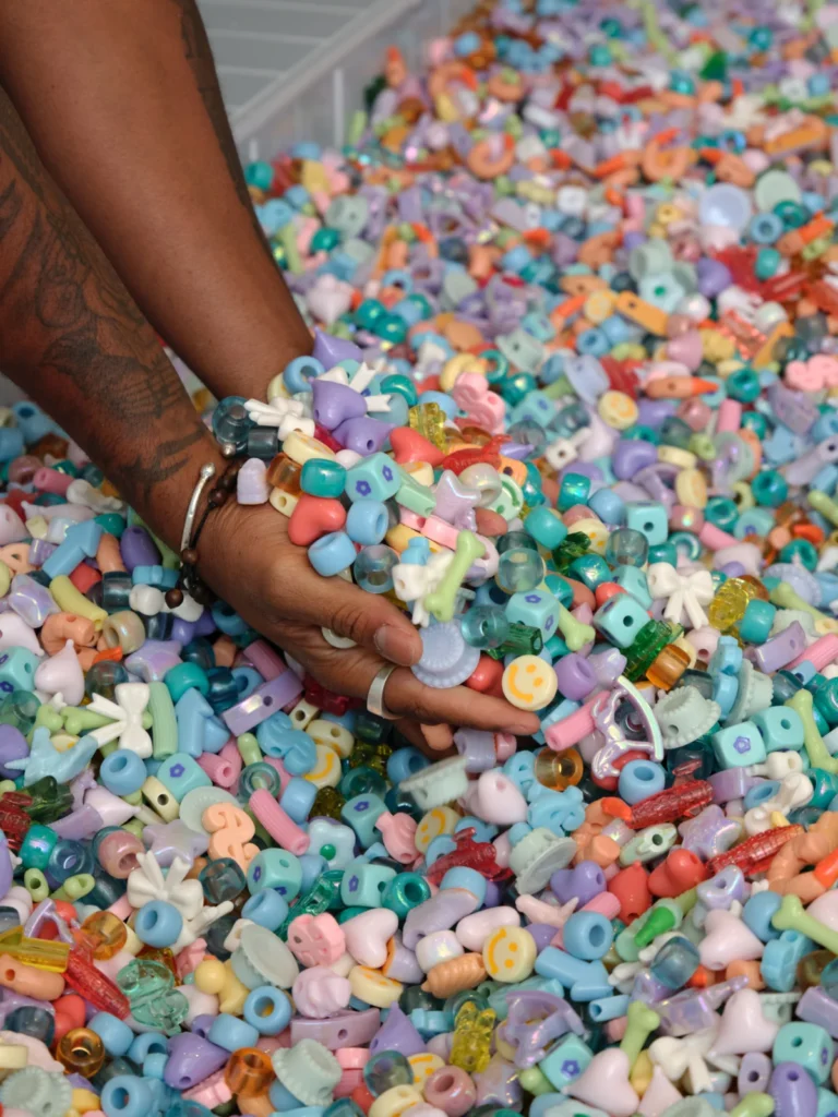 Visitors wading in a pastel bead pit installation