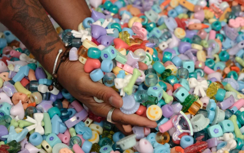 Visitors wading in a pastel bead pit installation