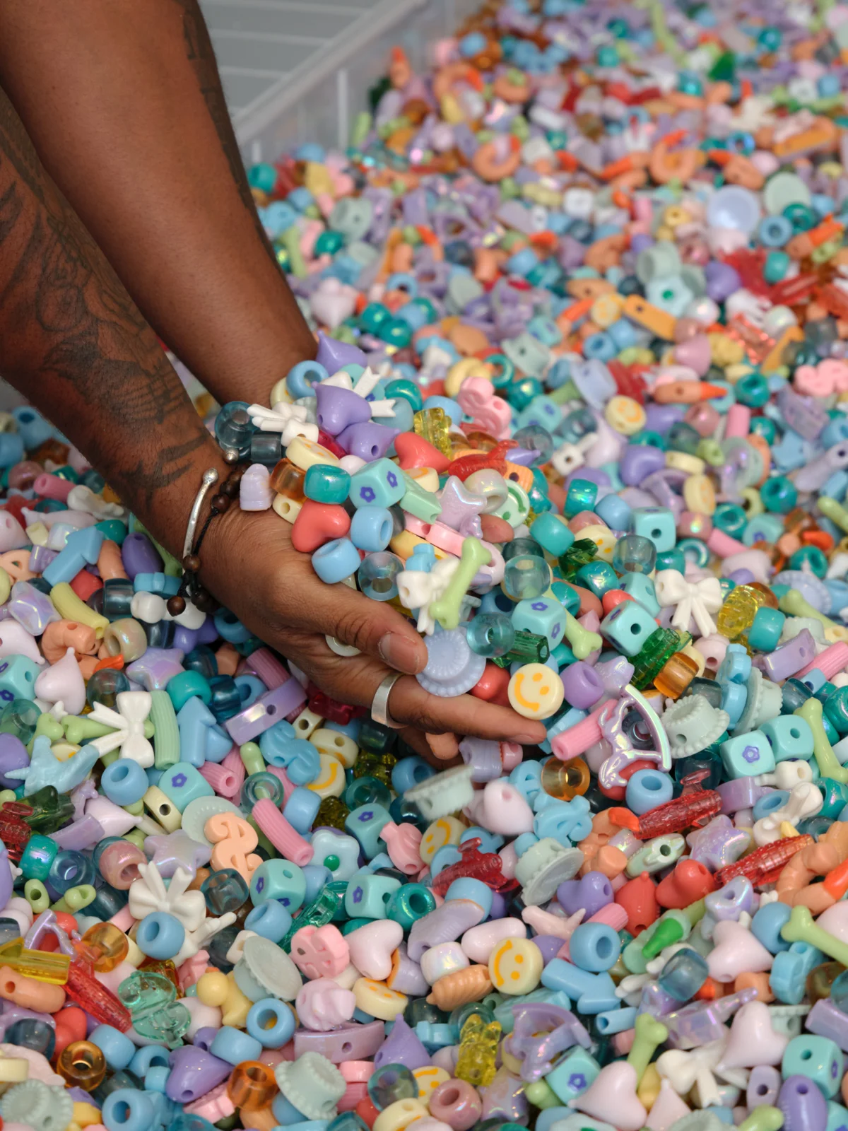 Visitors wading in a pastel bead pit installation
