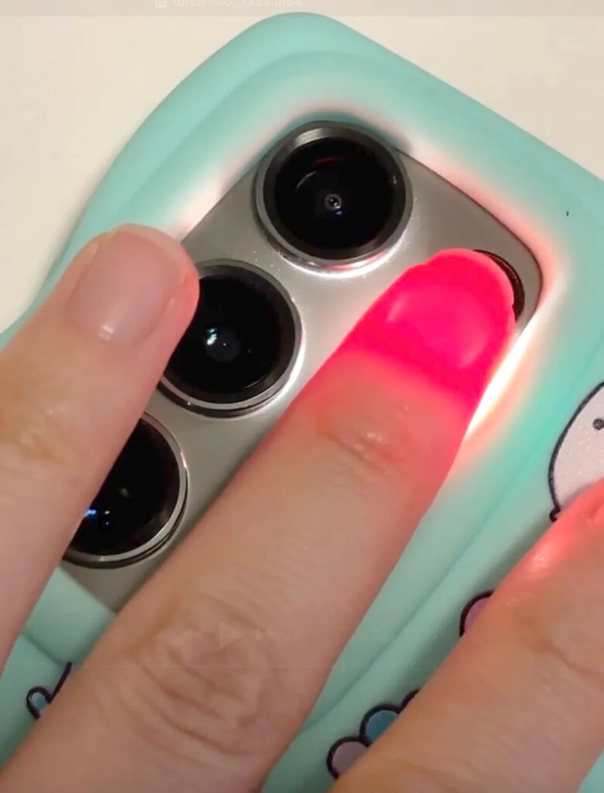 Fingertip illuminated by red light showing deep tissue penetration
