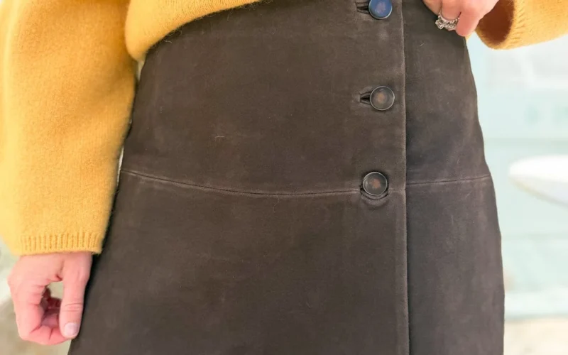 Mustard knit sweater and brown suede button-front skirt, face-free