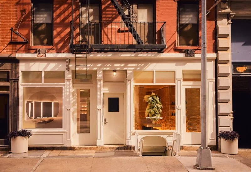 White store facade with large windows and potted plants