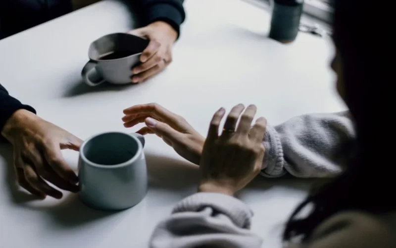 Two friends talking over coffee, one listening with care