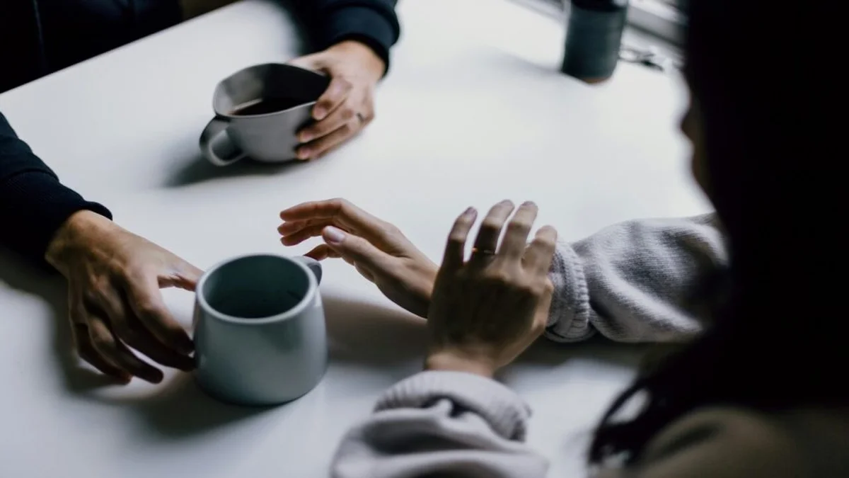 Two friends talking over coffee, one listening with care