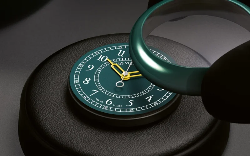 Green ceramic Louis Vuitton Monterey watch displayed on a black stand